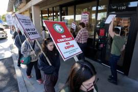 Trabajadores de Starbucks protestan frente a una de sus cafeterías, el viernes 20 de diciembre de 2024, en Burbank, California.