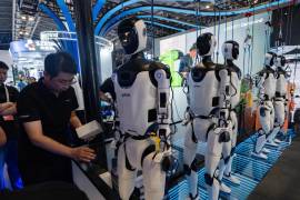 Un trabajador se encuentra cerca de robots de Efort, un fabricante chino de robots industriales, durante la Conferencia Mundial de Inteligencia Artificial en Shanghái, el viernes 17 de julio de 2026.