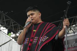 El rapero mexicano-triqui Carlos CGH, vestido con un “gabán” negro y rojo, una prenda nativa del pueblo triqui en Oaxaca, actúa durante una celebración de los pueblos indígenas en el Zócalo de la Ciudad de México.