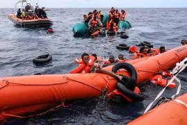 Migrantes que cayeron al agua intentan aferrarse a un flotador antes de ser rescatados por activistas, a unos 56 kilómetros de Libia, el 18 de octubre de 2021, en el mar Mediterráneo