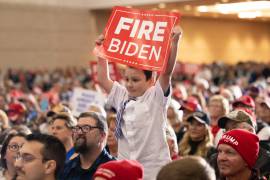 Un joven sostiene un cartel mientras el candidato presidencial republicano, el expresidente Donald Trump, habla en un mitin en Green Bay, Wisconsin.