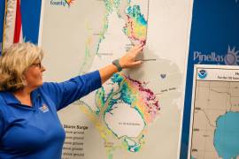 Cathie Perkins, directora de manejo de emergencias, señala un mapa en el que se indica dónde impactarían las marejadas en el condado Pinellas por el huracán Ian en Largo, Florida.