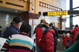 Habitantes de Pequín hacen largas filas para renovar su pasaporte.