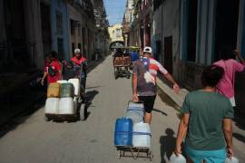 Varias personas transportan agua durante un apagón en La Habana, Cuba, el lunes 3 de agosto de 2026.