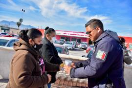 Personal de Seguridad Pública de Monclova entregando bebidas calientes en una jornada solidaria fuera del IMSS clínica 7.