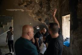 Varios palestinos se reúnen para reparar una vivienda dañada tras un ataque perpetrado el día anterior por colonos israelíes en el poblado de Sarra, cerca de la ciudad de Naplusa, Cisjordania.