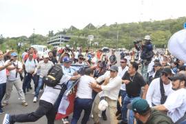 Funcionarios públicos se enfrentaron a maestros de la Sección 22 del SNTE durante el segundo informe de la presidenta en el auditorio Guelaguetza.