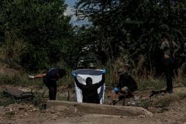 Una funeraria, a la izquierda, ayuda a las autoridades locales a recuperar un cuerpo en un campo a las afueras de Culiacán.