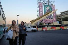 Dos personas pasan junto a un misil Khaibar-buster de fabricación nacional y pancartas con el retrato del líder supremo, el ayatolá Ali Jamenei (centro), y comandantes de las fuerzas armadas fallecidos en un ataque israelí en junio, en una exhibición militar para conmemorar el aniversario del inicio de la guerra con Irak y la guerra de 12 días contra Israel en junio, en la plaza Baharestan de Teherán, Irán, el 25 de septiembre de 2025. (AP Foto/Vahid Salemi)
