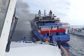 En esta fotografía se observa cómo un barco de rescate se acerca al ferry de pasajeros KM Barcelona 5 después que se incendiara en las aguas de la isla Talise en el norte de Sulawesi, Indonesia. FOTO: