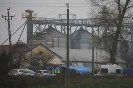 Los oficiales de policía trabajan afuera de un depósito de granos donde, según el gobierno polaco, la explosión de un misil de fabricación rusa mató a dos personas en Przewodow, Polonia.