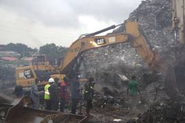Equipos de rescate buscan a personas entre un montón de basura tras un deslave en el mayor vertedero de Conakri, Guinea, el domingo 23 de agosto de 2026.