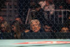 Donald Trump, visto a través de la valla metálica de un evento de la UFC, un reflejo de su aislamiento político y la presión creciente que enfrenta.