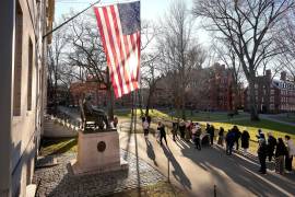 Unas personas toman fotos a la estatua de John Harvard, en la Universidad de Harvard.