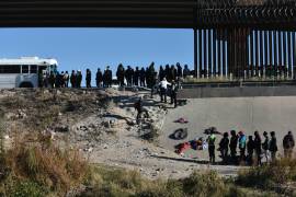 Decenas de migrantes esperan a subir a un autobús del gobierno estadounidense tras cruzar la frontera desde Ciudad Juárez, México, a El Paso, Texas, el 12 de diciembre de 2022.