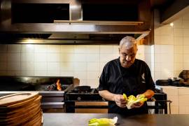 Ubaldo Aguirre trabaja entre brasas y frescura, equilibrando el fuego con la preparación de la ensalada.