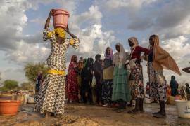 Mujeres y niños recogen agua al atardecer en el campamento de refugiados de Korsi en Birao, República Centroafricana, el 27 de marzo de 2026.