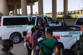 Migrantes esperan ser transportados a un centro de Aduanas y Protección Fronteriza de EE. UU. después de cruzar el Río Grande hacia Estados Unidos desde México en Eagle Pass, Texas, el 16 de mayo de 2022.