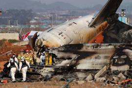 Los bomberos trabajan en los restos del avión Jeju Air en el Aeropuerto Internacional de Muan, 29 de diciembre de 2024. Las autoridades elevaron a 179 la cifra oficial de muertos en el accidente del avión comercial que se salió de la pista y chocó contra un vallado tras aterrizar.