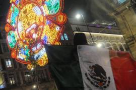 CIUDAD DE MÉXICO, 04SEPTIEMBRE2023. - Durante el encendido de la iluminación del Zócalo para las fiesta patrias, una mujer se coloca la bandera de México en su espalda y posa para una fotografía. FOTO: DANIEL AUGUSTO /CUARTOSCURO.COM