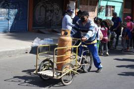 Un hombre en triciclo transporta un tanque de gas en la CDMX.