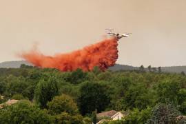 Un avión cisterna descarga agua durante el combate de incendios forestales en la región de Lège-Cap-Ferret, en el oeste de Francia, el jueves 23 de julio de 2026.