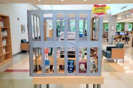 Fotografía de una jaula con varios libros censurados en su interior durante la celebración de la Semana de los Libros Prohibidos en una biblioteca pública en Miami (Estados Unidos).