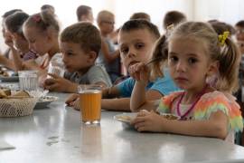 Niños de un orfanato de la región de Donetsk comen en un campamento en Zolotaya Kosa, un asentamiento a orillas del mar de Azov, en la región de Rostov (suroeste de Rusia), el 8 de julio de 2022.