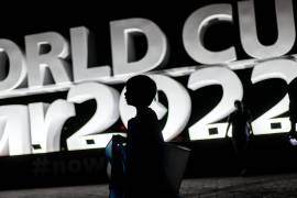 Un niño camina frente a un gran cartel del Mundial de Qatar 2022 en Doha, Qatar.