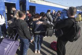 Refugiados ucranianos se despiden de sus familiares que parten hacia Polonia en una estación de tren en la ciudad de Odesa, en el sur de Ucrania.