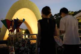 La gente ofrece oraciones por las víctimas en el 79 aniversario del bombardeo atómico de Hiroshima frente a un cenotafio durante la madrugada en el Parque Memorial de la Paz de Hiroshima en Hiroshima, Japón.