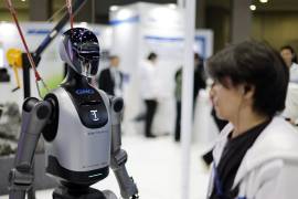 Un miembro del personal se encuentra junto al robot “Walker E” en el stand de GMO AI and Robotics Corporation durante la Exposición Internacional de Robots 2025 (iREX2025) en Tokio, Japón.