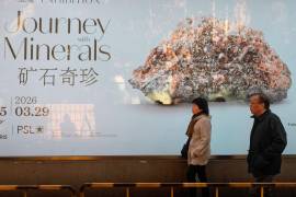 La gente pasa junto a un anuncio publicitario de una exposición de minerales en Shanghái, China. El dominio chino se refuerza por el control de los minerales de tierras raras.