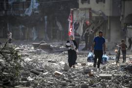 Palestinos caminan entre los escombros tras los ataques aéreos israelíes en el barrio de Tel al-Hawa, en la ciudad de Gaza.