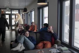 Científicos e ingenieros se relajan en la cafetería de Ny-Alesund, una estación de investigación internacional que constituye el asentamiento humano más septentrional del mundo, en el archipiélago noruego de Svalbard, en el océano Ártico, el 1 de mayo de 2025. Científicos de una estación de investigación internacional en la isla observan en tiempo real cómo el cambio climático transforma los ecosistemas.