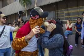 Después de haber convocado por redes sociales un encuentro entre Therians en la explanada de Rectoría de la UANL, dos jóvenes estudiantes con máscaras de animales se besan y se toman fotos con sus amigos.