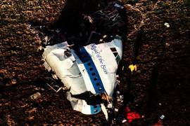 Policías e investigadores observan los restos de la sección de proa del vuelo 103 de Pan Am en un campo de Lockerbie, Escocia, en esta foto de archivo del 22 de diciembre de 1988.