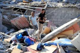 Los hombres permanecen sobre los escombros de un edificio alcanzado por un ataque aéreo israelí en la aldea sureña de Akbieh, Líbano, el 24 de septiembre de 2024.