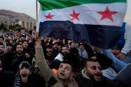 Ciudadanos sirios ondeando la bandera revolucionaria y gritando consignas en celebración de la toma de la ciudad por parte de los insurgentes en Damasco, Siria.