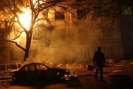 Un hombre camina frente a un edificio residencial en llamas después de un ataque ruso en Zaporiyia, el 26 de noviembre de 2025.