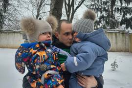 Tras un intercambio de prisioneros, Artem Dmytryk abraza a su hijo Timur, de dos años (derecha), y a un sobrino en Kiev, Ucrania, el 9 de febrero de 2024.