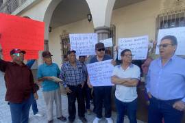 Vecinos de Villas del Desierto marchan con pancartas en demanda de escrituras prometidas por el Gobierno del Estado.