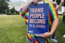 Una persona sostiene un cartel que dice “Las personas trans pertenecen a Alabama” en una protesta frente al Capitolio estatal de Alabama en Montgomery.