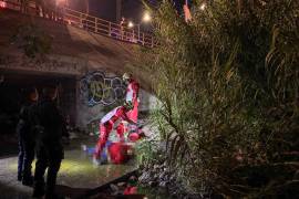 Elementos de la Policía Municipal y paramédicos de la Cruz Roja se coordinan para el rescate de la mujer en el arroyo.