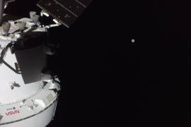 Esta imagen proporcionada por la NASA muestra la nave espacial Orión con la Luna a lo lejos, captada por una cámara ubicada en la punta de uno de sus paneles solares.