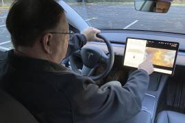 Vince Patton, un nuevo propietario de Tesla, demuestra en un campo cerrado en Portland, Oregon, cómo puede jugar videojuegos en la consola del vehículo mientras conduce. AP/Gillian Flaccus