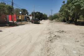 Tramos abiertos y material abandonado reflejan el rezago en la pavimentación de la vialidad.