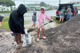 Kenzielynn Kekoa (centro), de Hilo, Hawai, ayuda a su familia a llenar sacos de arena ante la cercanía del huracán Nolo, el 25 de septiembre de 2026, en Hilo, Hawai.