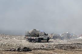 Los equipos trabajan en conjunto para controlar el fuego en un relleno sanitario.