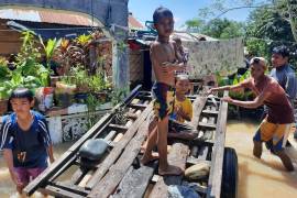 Unos niños arrastran un carrito en el pueblo inundado de Tuka, en el municipio de Mamasapano, provincia de Maguindanao, Filipinas.